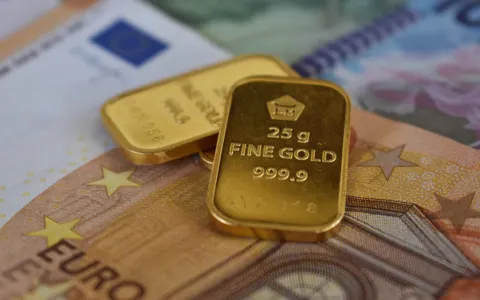 Lingotes de oro sobre billetes de euro